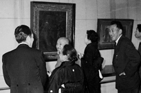 石橋美術館において青木繁《自画像》の前に立つ坂本繁二郎(中央、1960年)